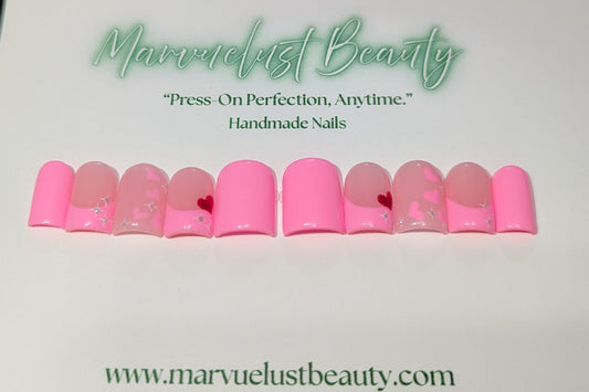 Soft pink press-on nails with decorative elements on a white background, featuring 'Marvuelust Beauty' branding.