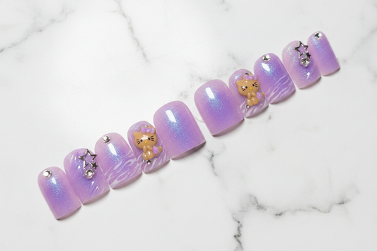 Purple nail art with cat figures and rhinestones on a black background