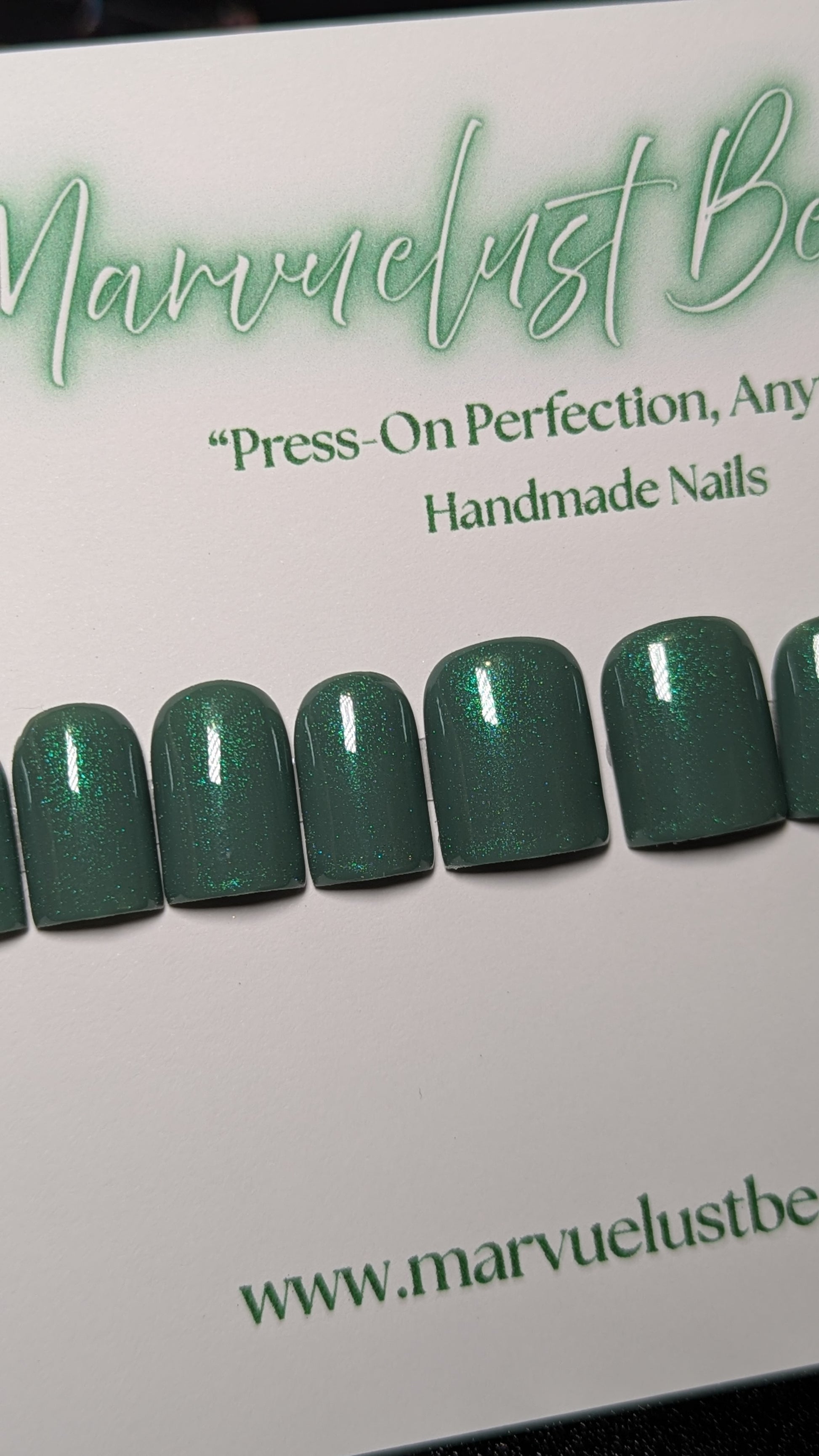 Set of green press-on nails with 'Marvuelust' branding on a white background